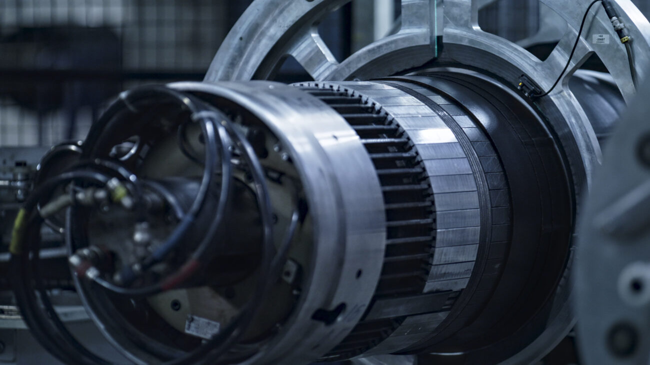 778556 Volta - Haznoticia.com Close-up of a large industrial turbine shaft with metal housing and cables in a factory setting